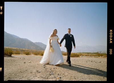 couple in traditional indian wedding attire holds hands
