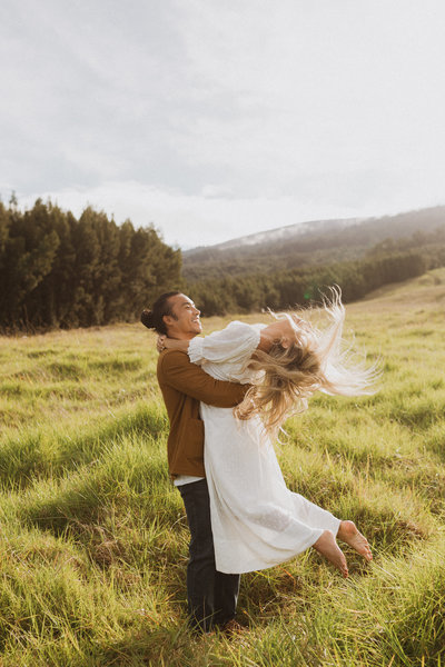 bride and groom laughing in field