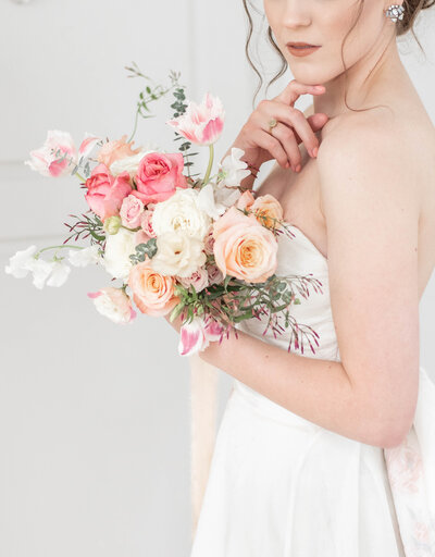 bride holds pink and peach bouquet