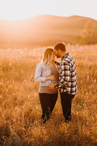 The golden sunset north of Bismarck lets a couple embrace and take in a peaceful moment during their maternity session.