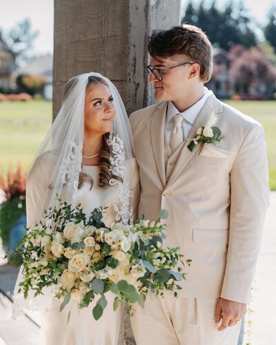 a bride and groom smiling at each other