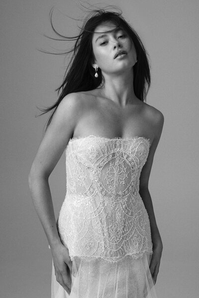 Bride in a strapless lace corset dress, photographed in black and white.