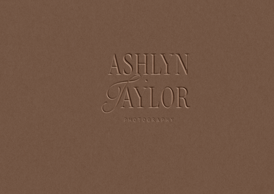 Debossed-style logo mockup on brown textured background reading ‘Ashlyn Taylor Photography’ with elegant serif and script font pairing.