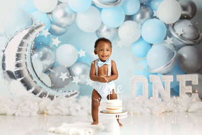 Baby in a blue themed cake smash setup