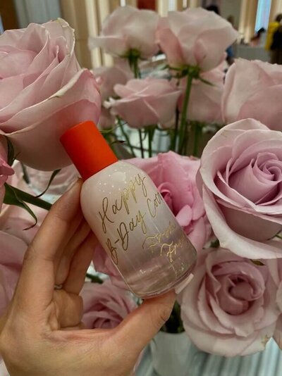 cream bottle with gold calligraphy engraving saying happy birthday