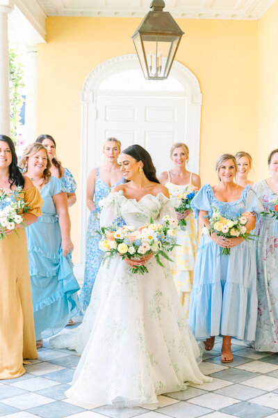 Bride and bridemaids walking together at the William Aiken House by Charleston, SC wedding photographer Dana Cubbage.