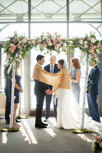 A jewish couple stands under their chuppah at a restaurant in Yonker NY