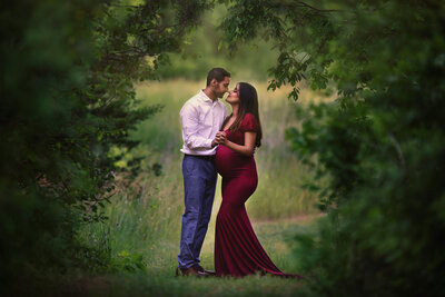 Couple standing under trees at their Southeast Michigan maternity session