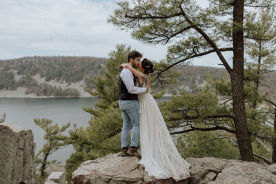 bride and groom standing on a beach with the ocean waves