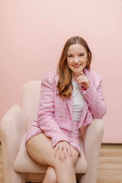 Woman wearing pink pant suit smiling for camera