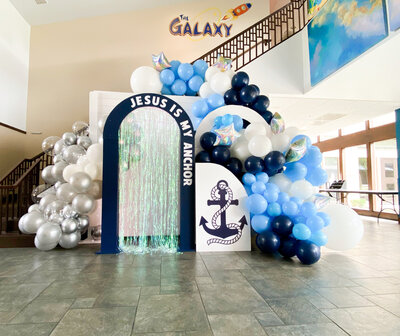 Blue and white nautical themed backdrop design with balloon arches