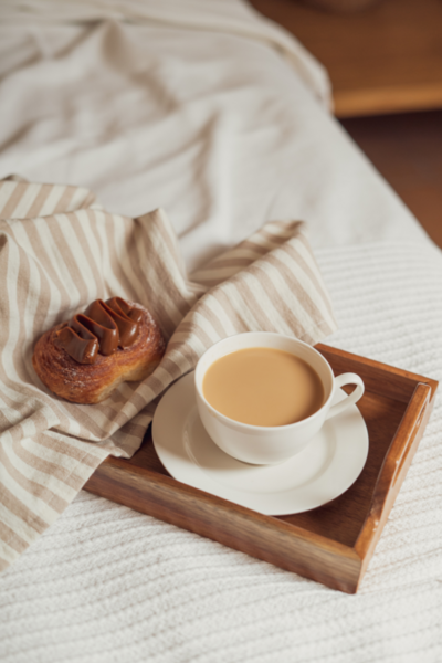 Coffee and croissant on luxury bed