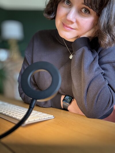 a smiling social media manager is looking at a computer screen