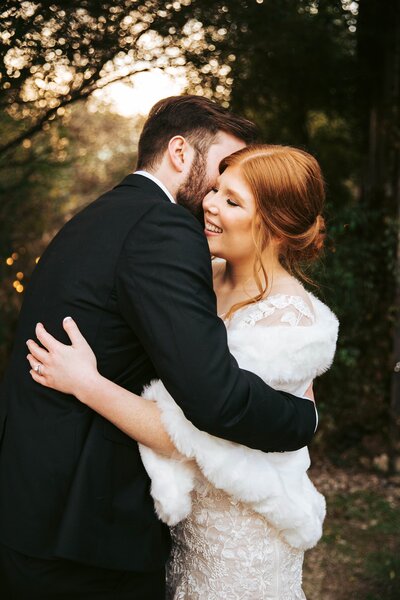 bride and groom holding each other and smiling on wedding day