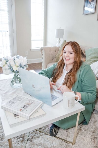 Elyse Stokes from E Stokes Creations, smiling while browsing on her laptop