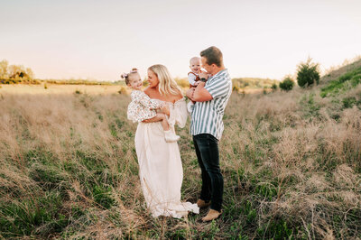 Springfield MO family photographer captures family laughing and cuddling in field