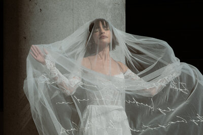 Bride covered by a veil in the sun in an industrial exterior terrasse setting
