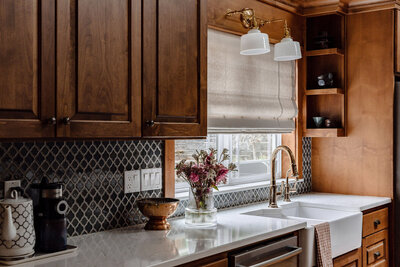 A kitchen counter, farm sink and cupboards representing a custom home interior design.