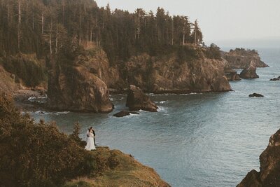 A couple standing on a cliff overlooking the ocean on 35mm film