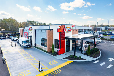 Drone photograph of a Cane's fast food restaurant from the front corner.