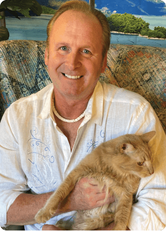 Christian in a light shirt holding his pet cat