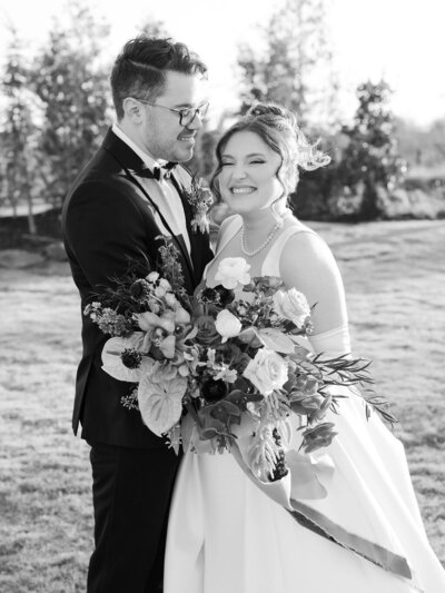 A black and white portrait of a bride and groom smiling at their wedding in Tulsa, Oklahoma.