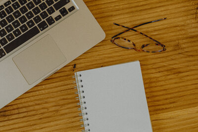 Virtual Assistant Desk, Macbook Laptop and Glasses to Work and Inquire Services.