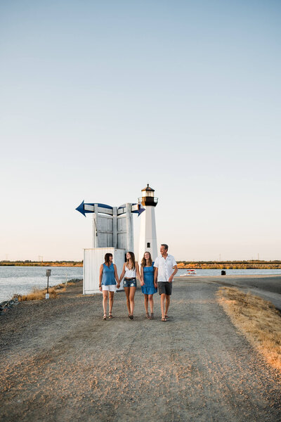Family walking hand in hand by the lake at sunset, captured by Vanessa Montano Photography — Brentwood Family Photographer creating candid, timeless portraits.
