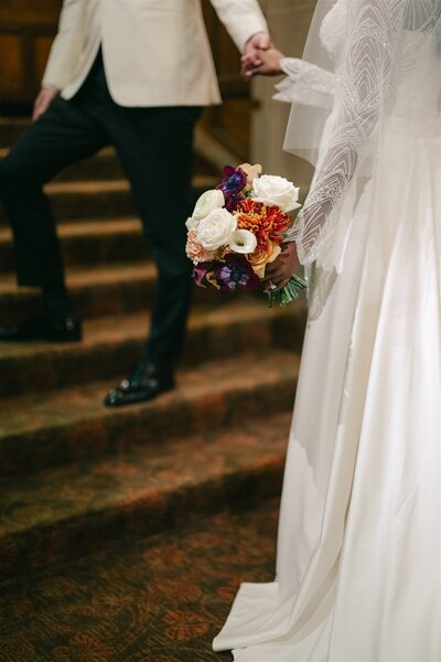 wedding reception table with white, orange, and yellow flowers
