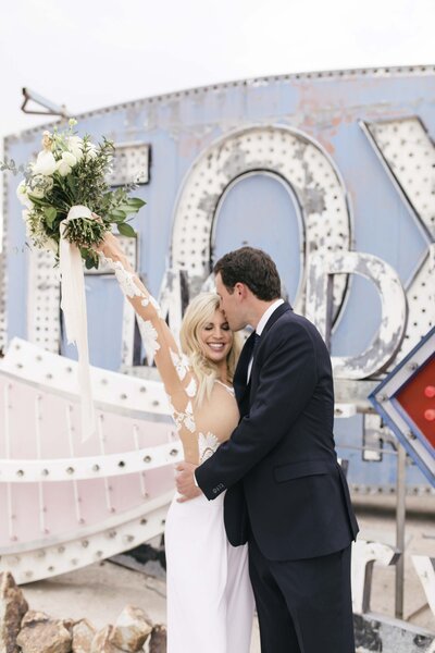 engaged couple celebrating in front of sign