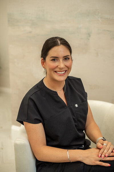 brunette female nurse wearing black scrubs