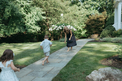 two kids running to mom during family photos captured by NYC family photographer Elsie Goodman