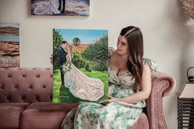 Debbie proudly showing off a completed painting by holding it up for the camera