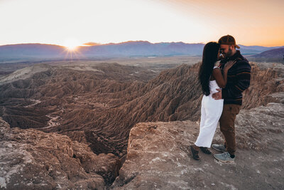 A couple standing on a canyon edge, enjoying a luxury adventure in a hidden national park location away from the crowds