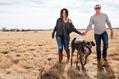 woman in New Mexico field  hugging  dog