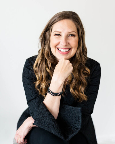 A client smiling directly at the camera during a headshot session.