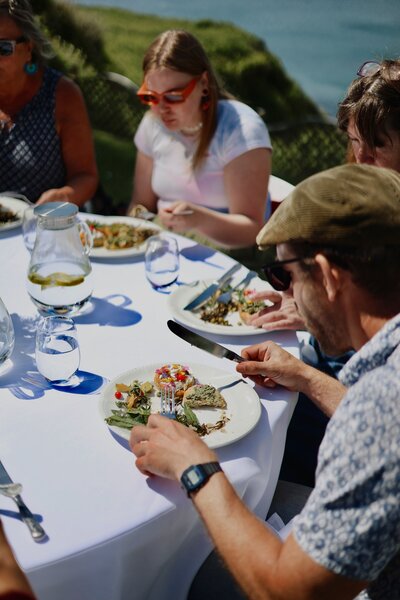 People enjoying their fabulous foraged food on the Polhawn Fort lawn.