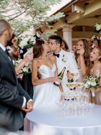 bride and groom kiss at champagne tower