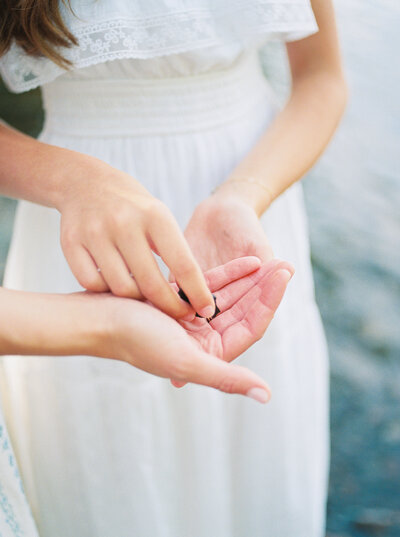 Tween daughter's hand places lake rock into mother's hand captured on film by photographer Little Rock