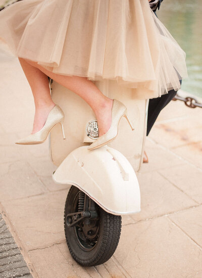 women in heels and skirt on back of moped
