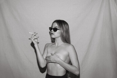 girl wearing sunglasses smoking a cigarette