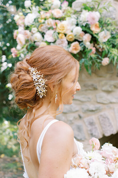Bridal loose updo with diamond clip and florals