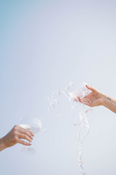 Two glasses splashing liquid mid-air during a branding session at Western Michigan University.