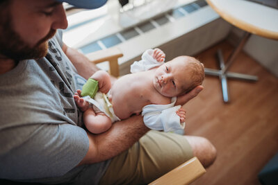dad holds newborn daughter in hospital room during fresh 48 pictures