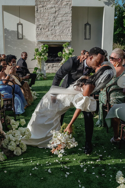 Couple walking back down the aisle at The Arlo and sharing a kiss as they exit 