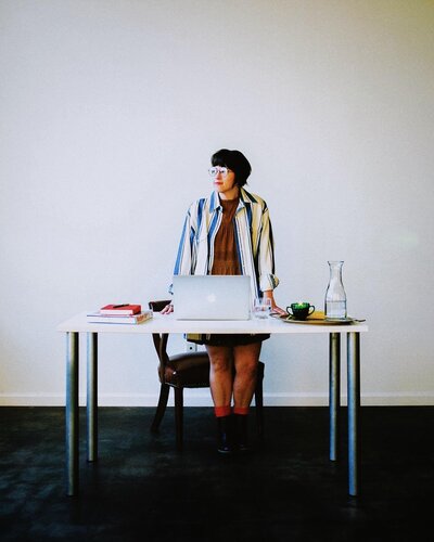 A woman standing over her desk
