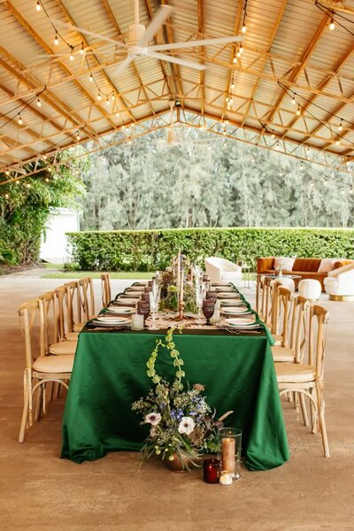 satin green tablescape with whimsical florals under barn in private lakehouse