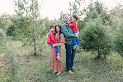 Couple holding sons in Blue Acres Tree Farm for Tampa fall mini session.