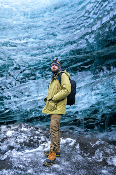 Nathan Sottung poses inside an ice cave during his first visit to Iceland, where he explored stunning landscapes, witnessed the northern lights, and embraced his adventurous spirit while capturing the beauty of the country.