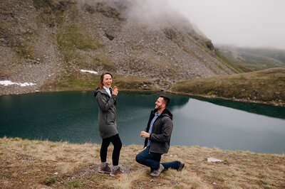 couple proposing above lake